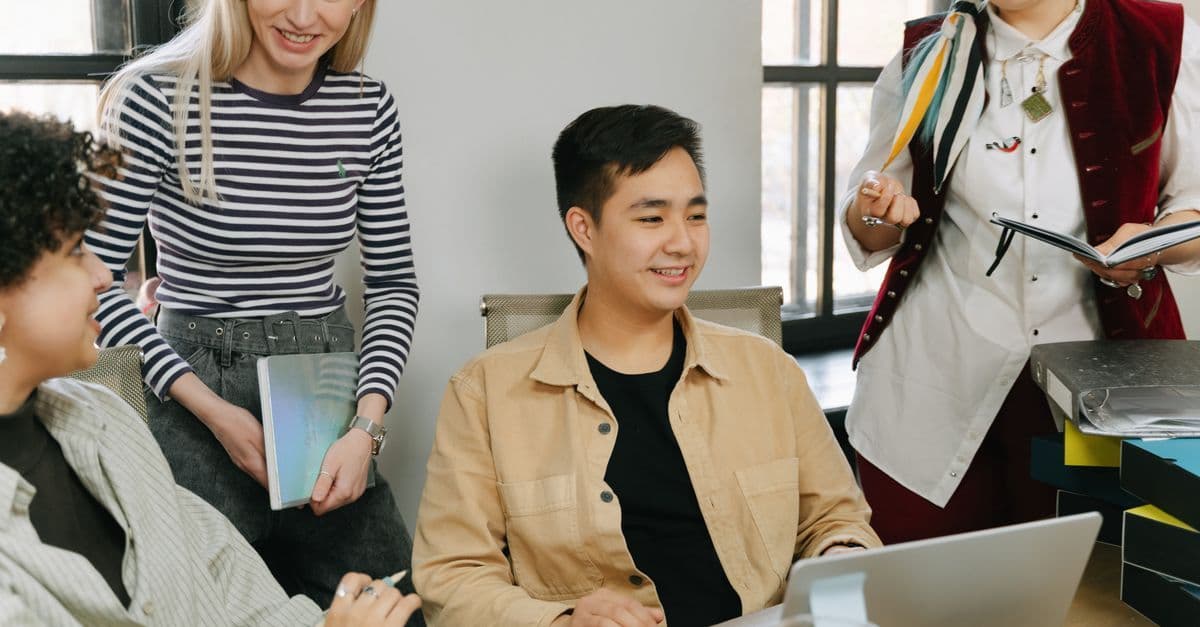 Team in einem Büro arbeitet gemeinsam an einer positiven Unternehmenskultur als Ausdruck interner Arbeitgebermarke