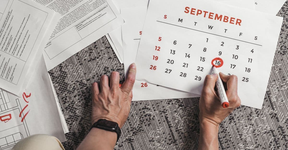 Kalender auf einem Schreibtisch mit markierten Wochenend- und Feiertagen zur Veranschaulichung der Arbeitstage-Berechnung