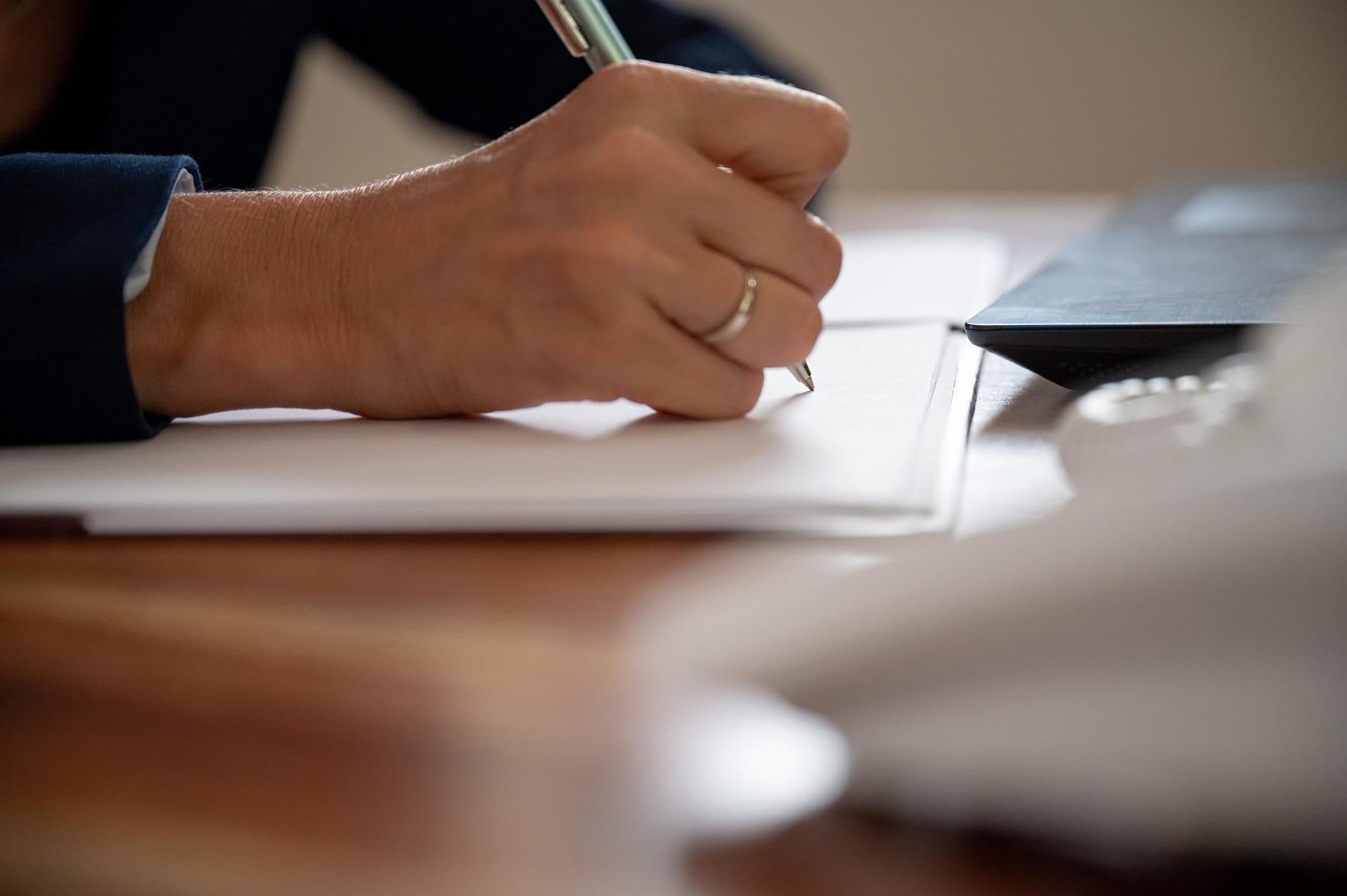 Arbeitnehmer verfasst schriftlichen Antrag auf unbezahlten Urlaub am Schreibtisch