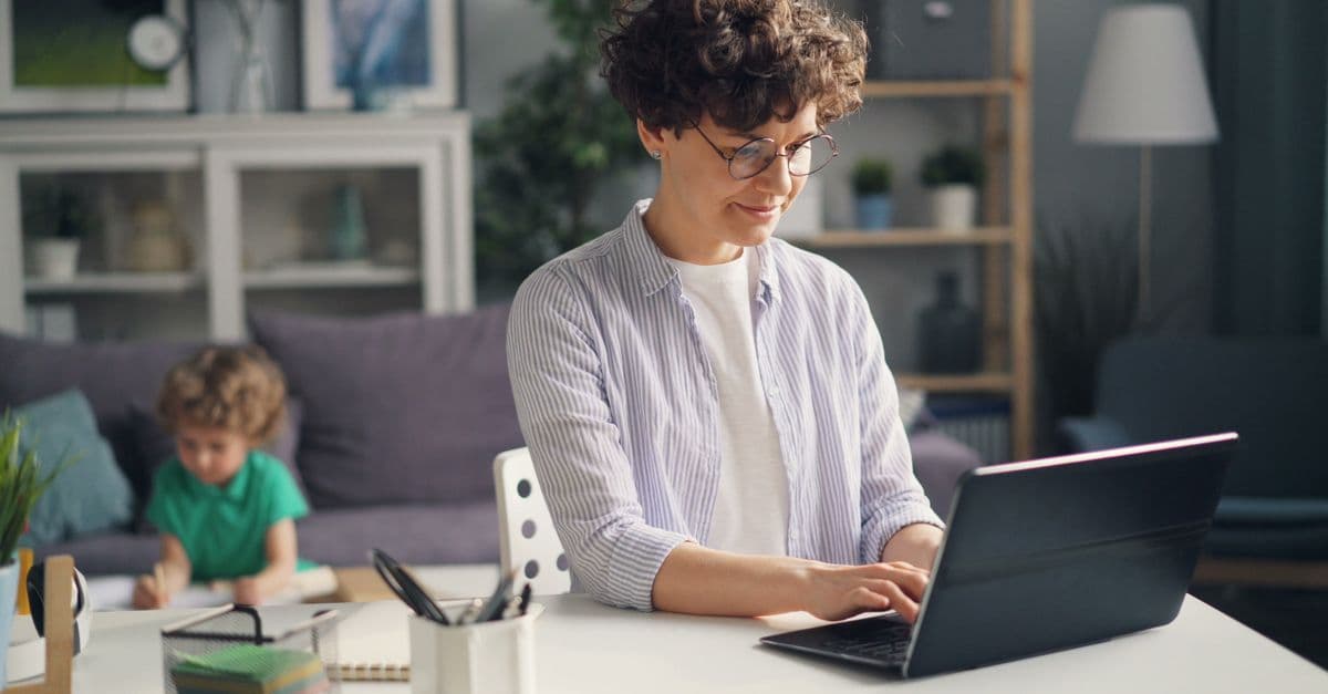 Symbolbild für Work-Life-Blending: Person arbeitet flexibel im Homeoffice mit Blick auf familiäres Umfeld