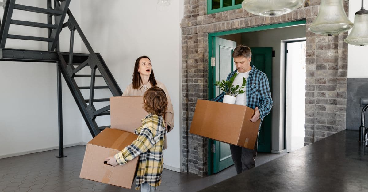 Familie trägt Umzugskartons am Wochenende bei einem privaten Umzug