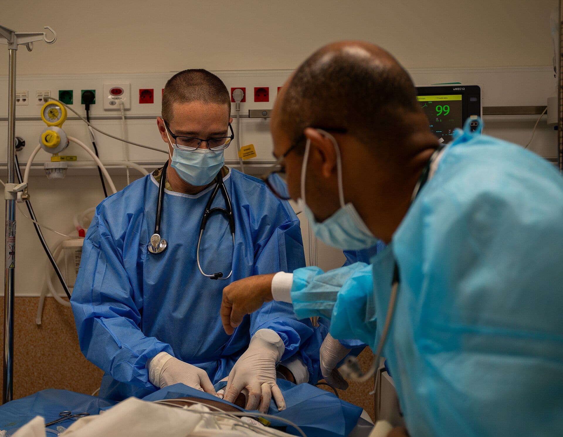 An Angolan Army health professional directs U.S. Army Capt. Christopher Bellm, an emergency medicine physician assistant (65DM2), in inserting a central line, providing the medical team with direct access to administer medication to the patient. Bellm and Ford worked alongside Angolan military health professionals in the emergency room during the Medical Readiness Exercise (MEDREX) in Luanda, Angola, July 9, 2024. MEDREX is a medical readiness exercise program, planned and executed by U.S. Army Southern European Task Force, Africa (SETAF-AF), that allows military health professionals from the U.S. and their African partners to exchange medical practices, procedures and techniques that build and strengthen treatment capabilities, resulting in lasting relationships between the partners.(U.S. Army photo by 1st Lt. Katherine Sibilla)