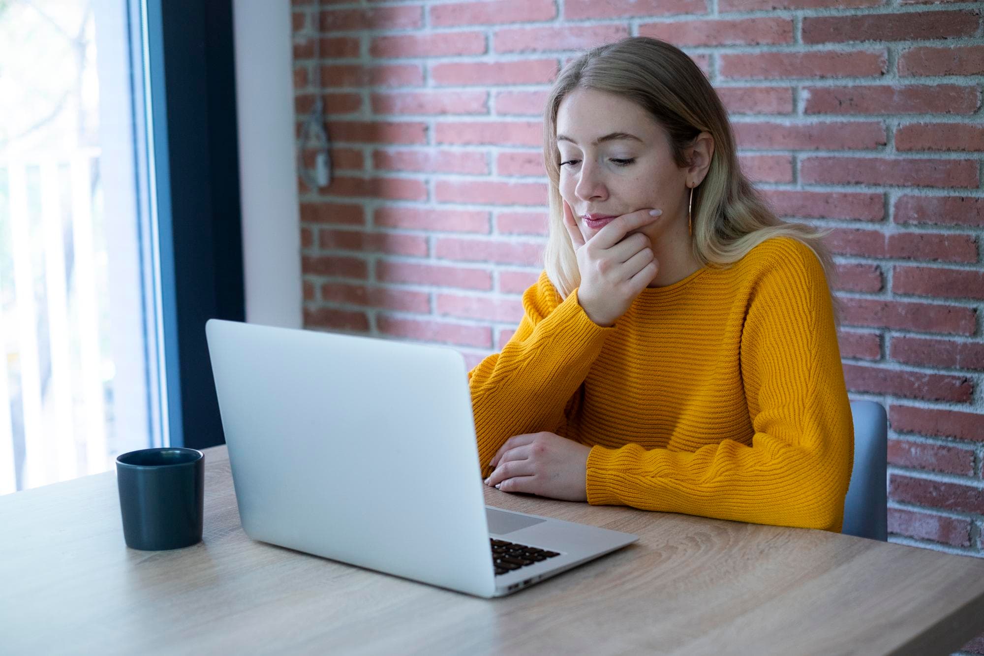Person überlegt am Laptop, wie sie den Rückzug ihrer Bewerbung formulieren soll, um Fehler zu vermeiden