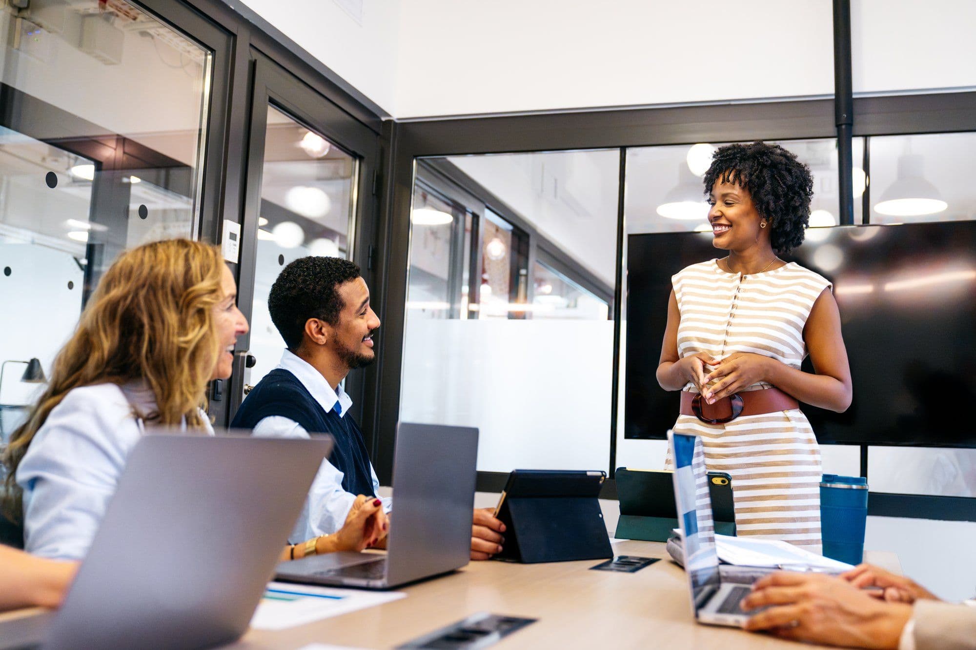 Team im Gespräch mit Führungskraft in modernem Büro als Sinnbild für New-Work-Leadership