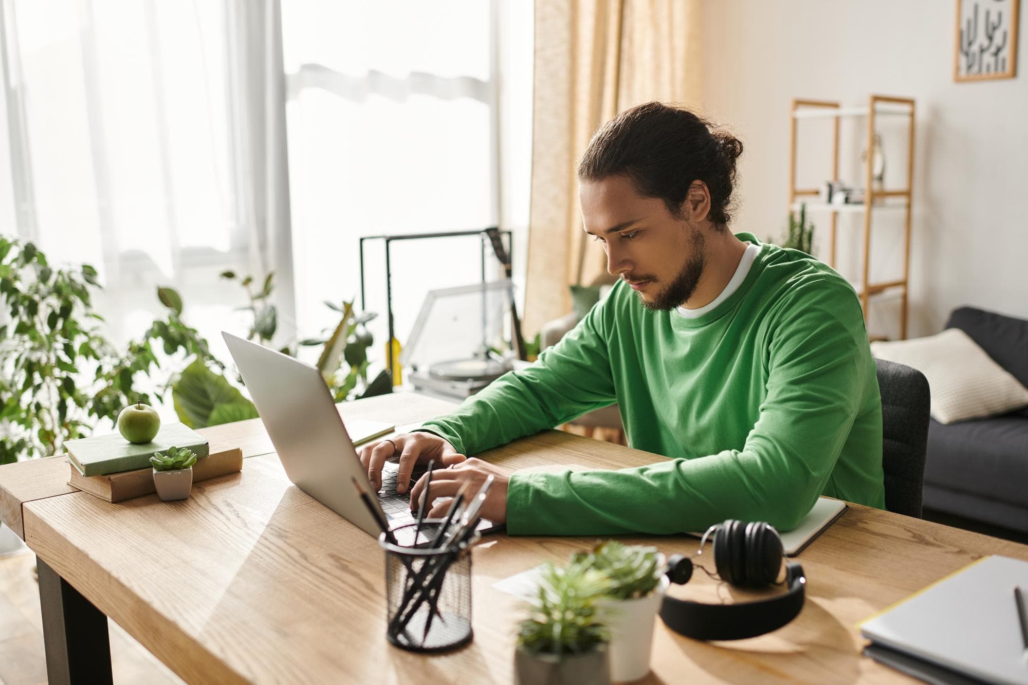 Person arbeitet konzentriert im Homeoffice am Laptop, Symbolbild für einen Nebenjob während der Krankschreibung