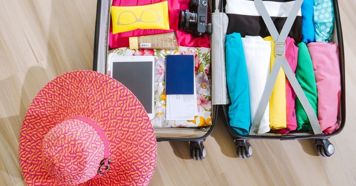 Gepackter Koffer und Reisepass als Symbolbild für die Abwesenheitsnotiz im Urlaub