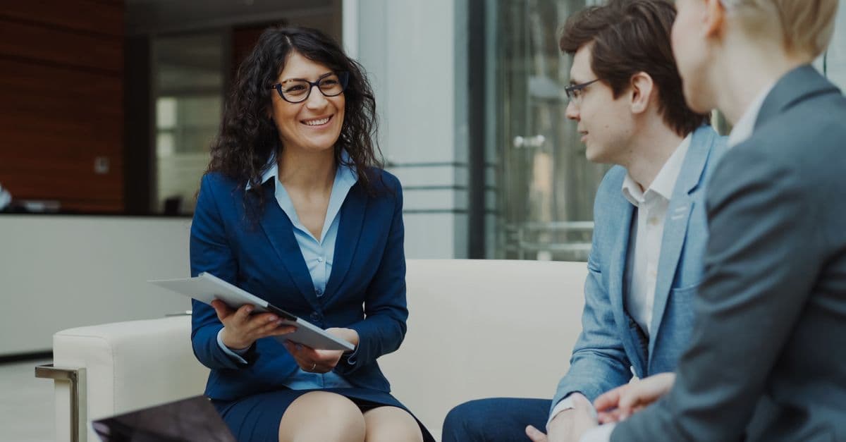 Professionals discussing business strategy in a corporate office setting.