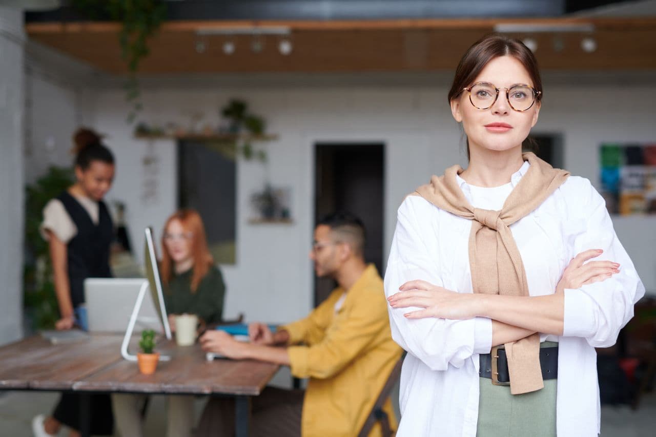 Selbstbewusste Geschäftsfrau in einem modernen Büro, die Erfolg und Führung verkörpert.