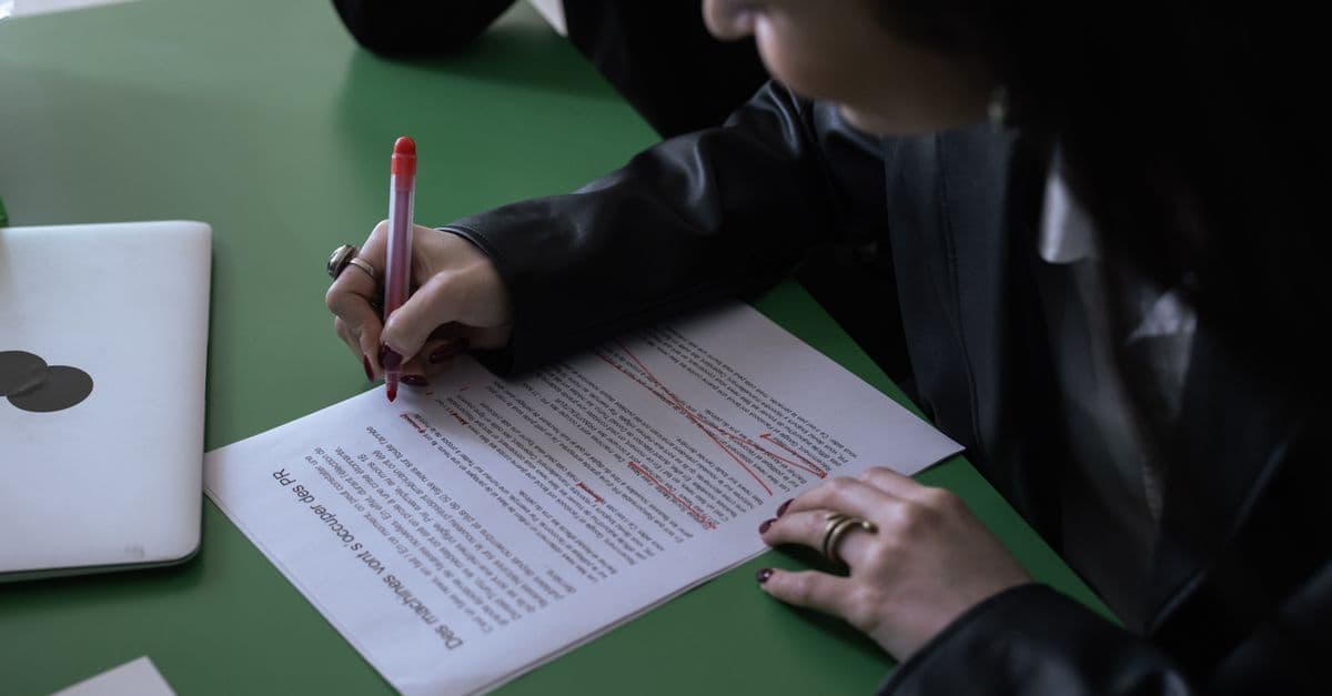 Person korrigiert ein Arbeitszeugnis mit rotem Stift, um typische Fehler zu vermeiden