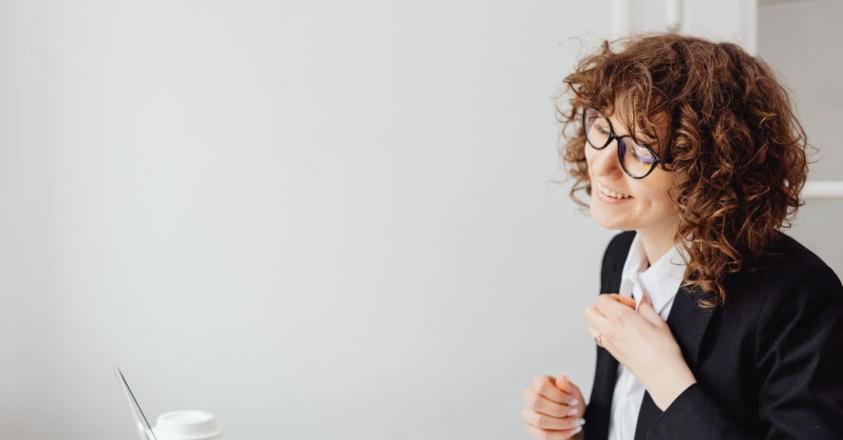 Frau mit lockigem Haar im Büro am Ende des Arbeitstags