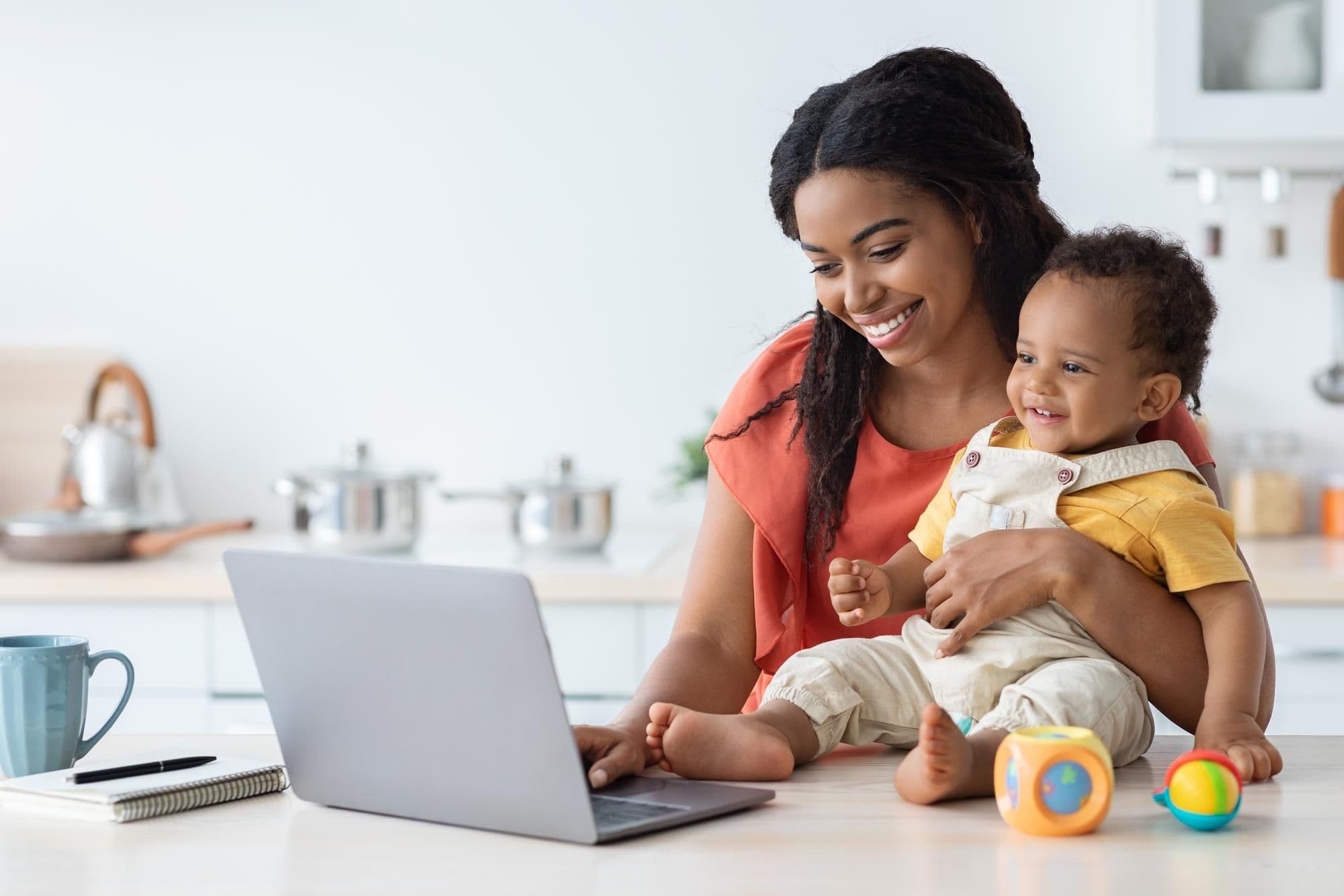 Elternteil mit Baby zu Hause als Symbolbild für die Abwesenheitsnotiz während der Elternzeit
