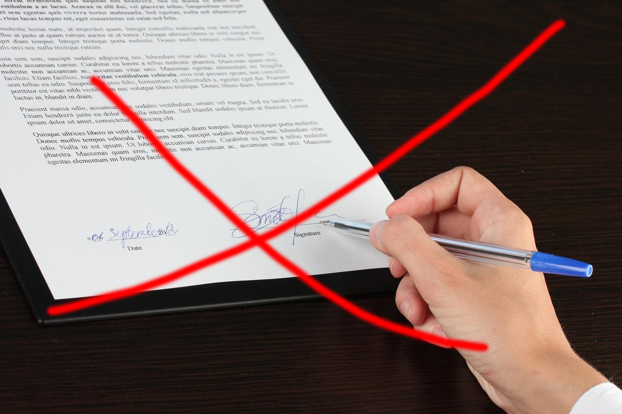 Roter Stift markiert einen Fehler auf einem unterschriebenen Kündigungsschreiben