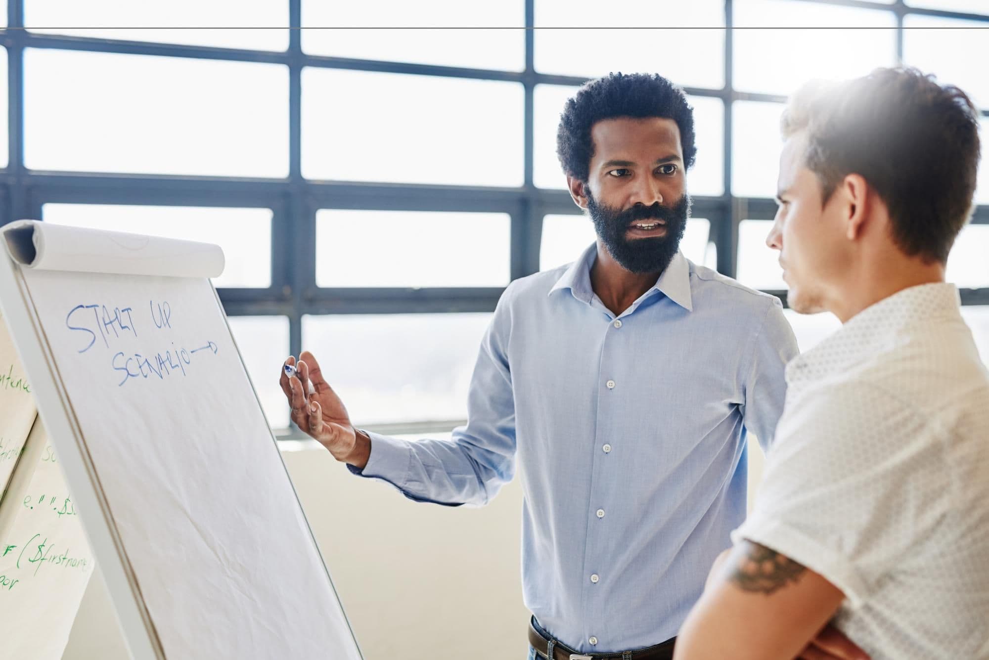 Training manager and business men with startup scenario talk at board for strategy meeting and planning Discuss advice and mentor with teamwork and staff in conversation for project brainstorming