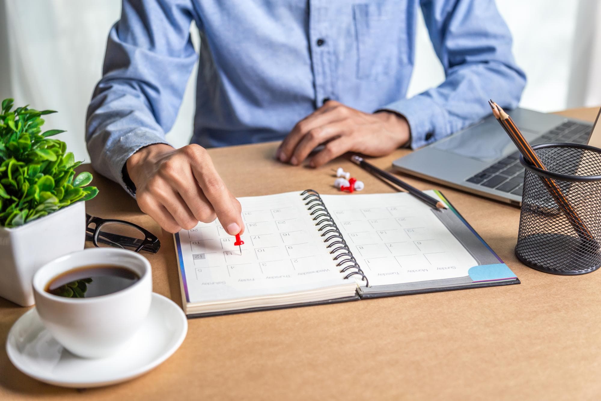 Fach- oder Führungskraft plant die Sabbatical-Auszeit anhand einer Checkliste mit Kalender und Notizen