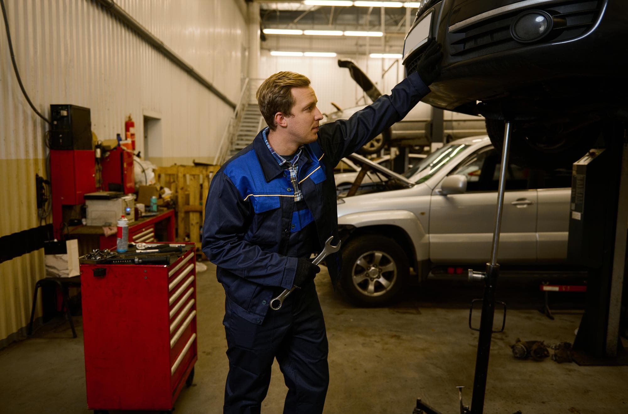 Kfz-Mechatroniker bei der Reparatur eines Fahrzeugs in einer Werkstatt
