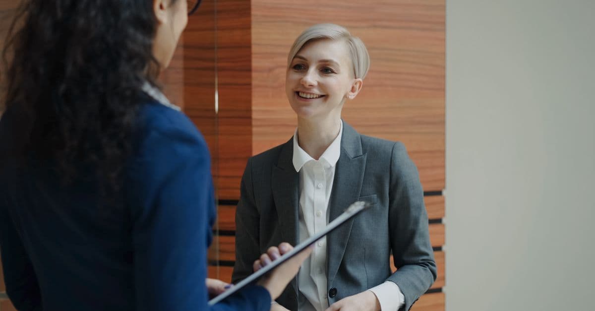 Two professionals having a conversation during a business meeting indoors.
