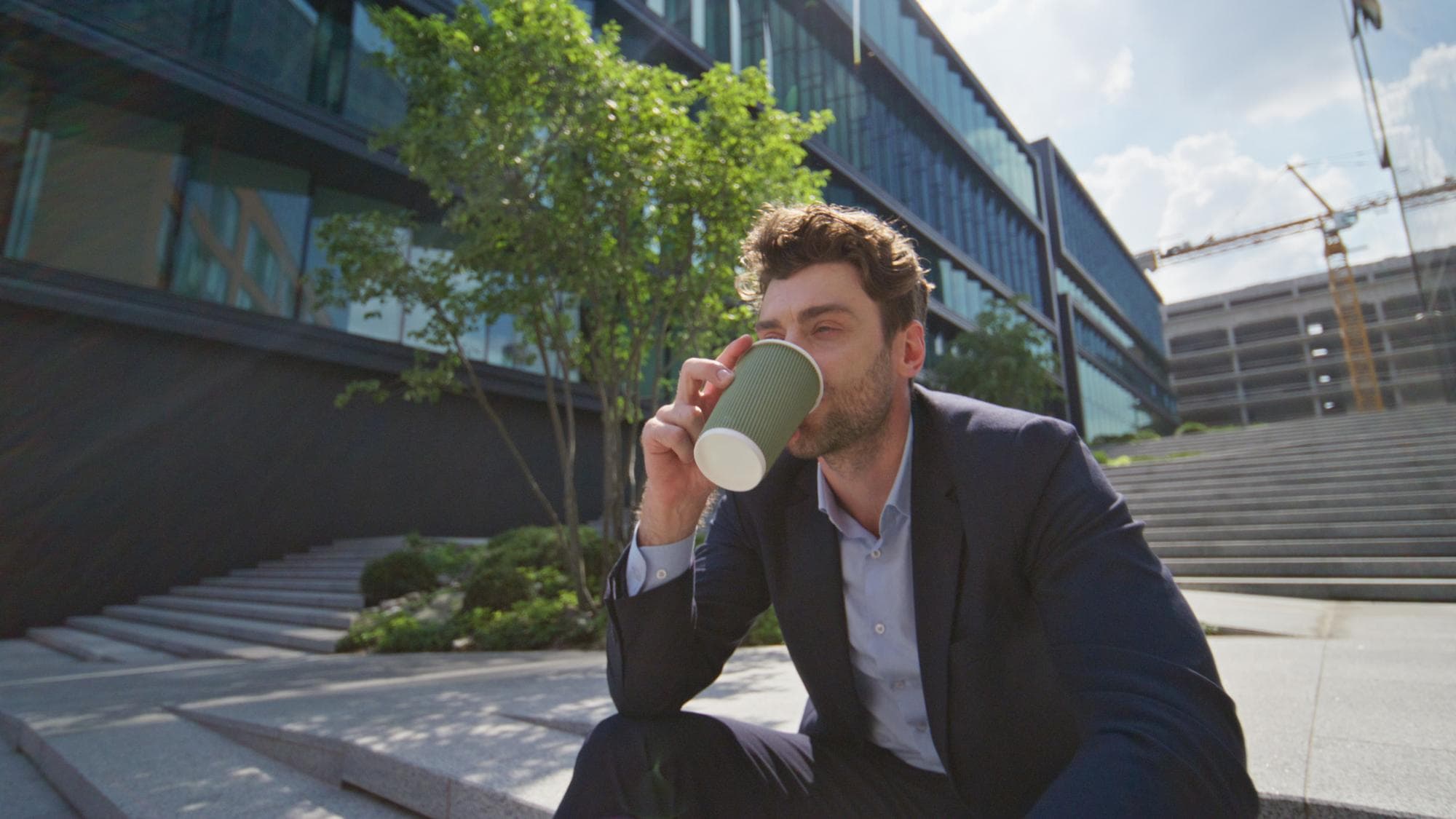 Angestellter macht eine kurze Kaffeepause vor dem Bürogebäude, die nicht als gesetzliche Ruhepause zählt