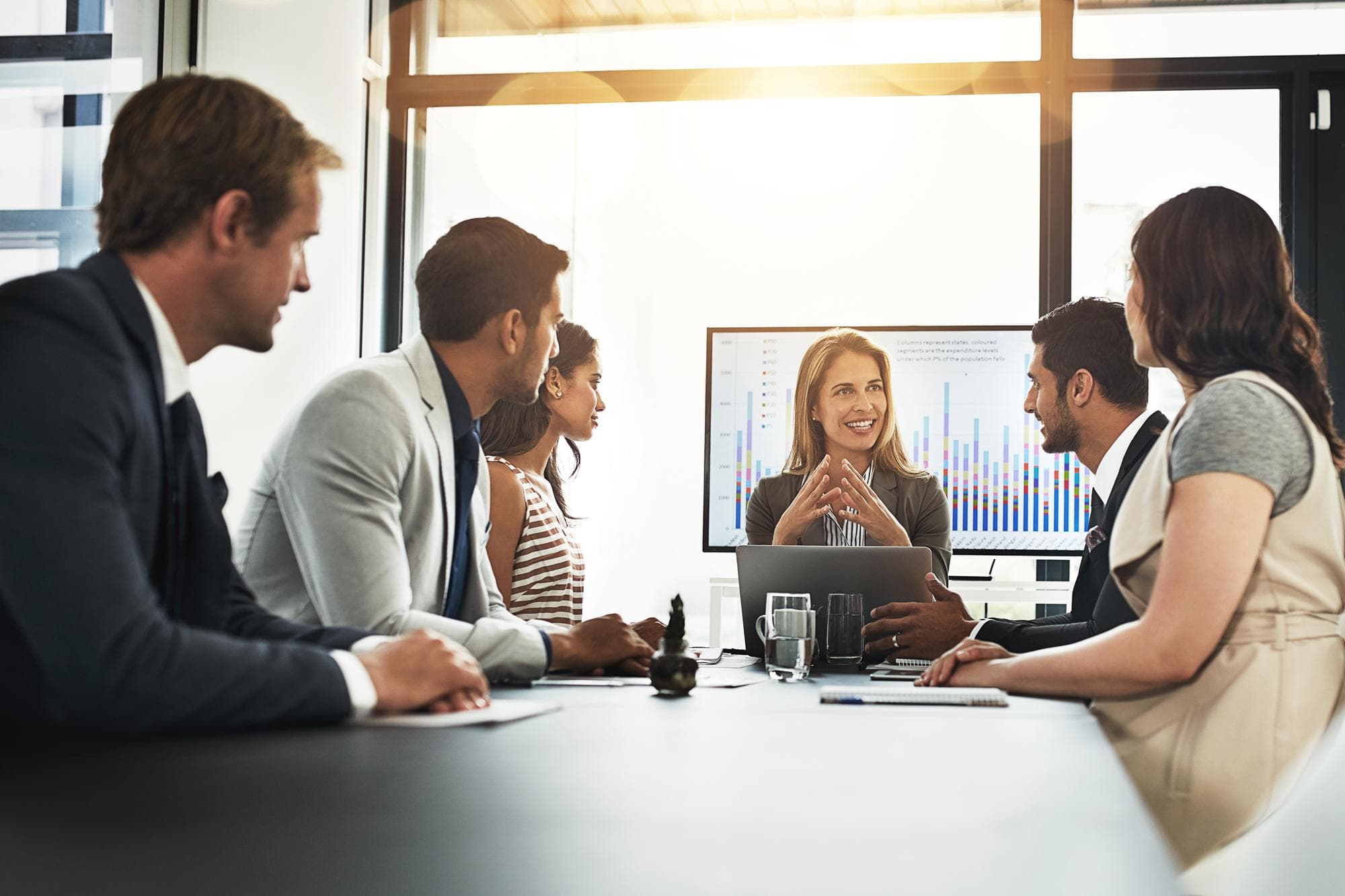 Business people meeting and conversation with data on screen for hr metrics review insights and planning Leader talking and human resource analytics for employee performance and profit management