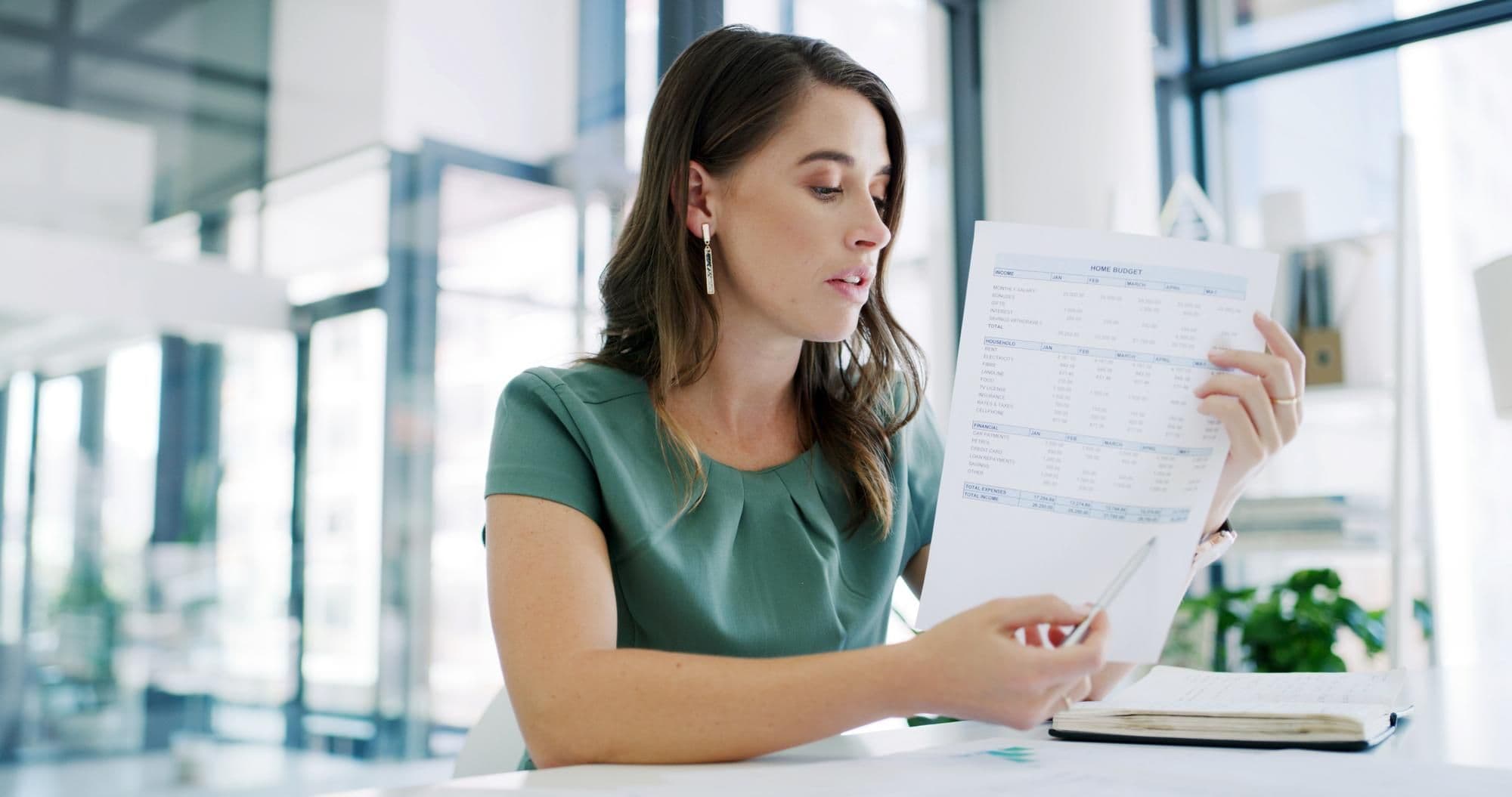 Business woman accountant and discussion with documents for finance payslip or revenue in office Female person accounting or meeting with paper financial expenses or company budget in workplace