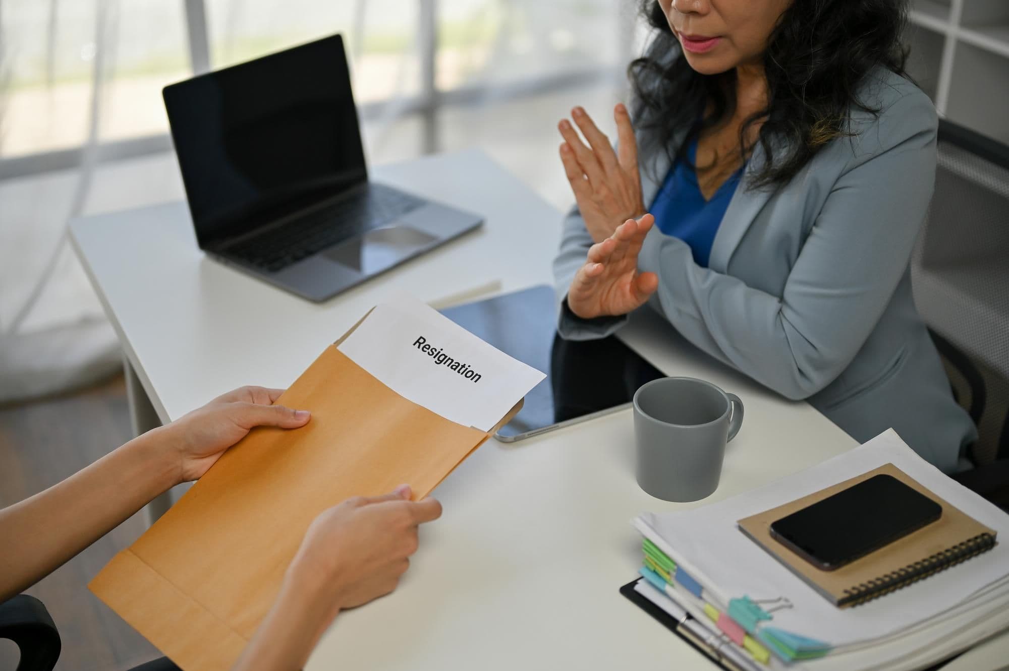 A senior businesswoman is talking about resigning and trying to compromise with a male employee