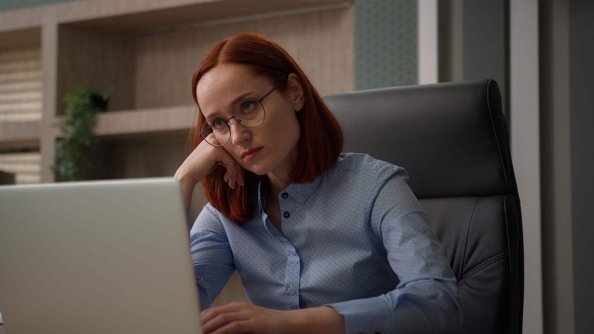 Bored sad Caucasian female girl worker tired unmotivated disinterested in online office work with laptop lazy businesswoman employee business woman lack of motivation annoyed with boredom boring job