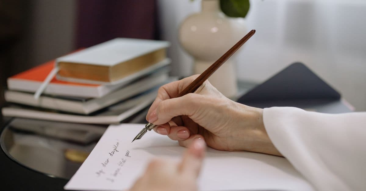 Person formuliert schriftlich den Antrag auf Verlängerung der Elternzeit am Schreibtisch
