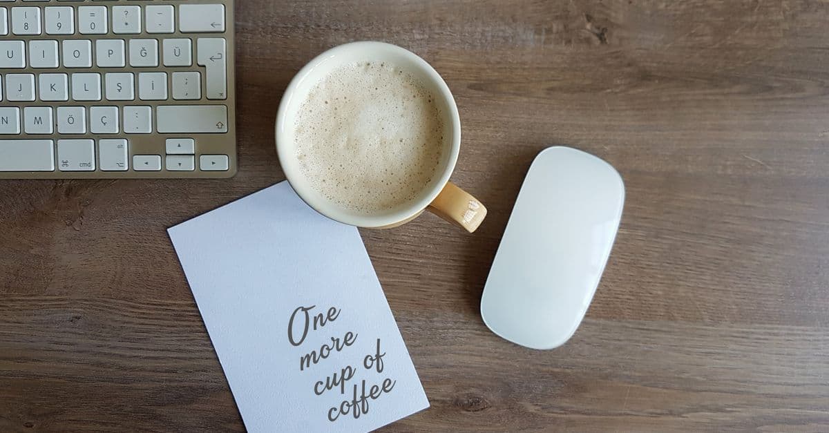 Kaffeetasse und Notizzettel auf einem Schreibtisch als Symbol für den Start in den Montag im Büro