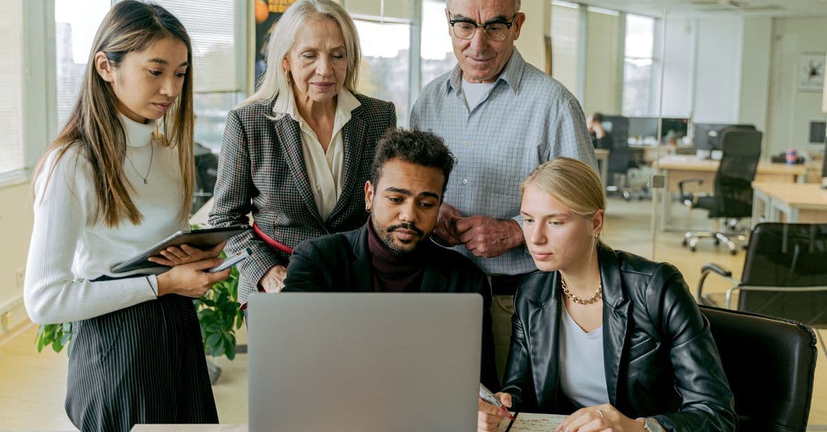 Mitarbeitende unterschiedlicher Generationen arbeiten gemeinsam im Büro