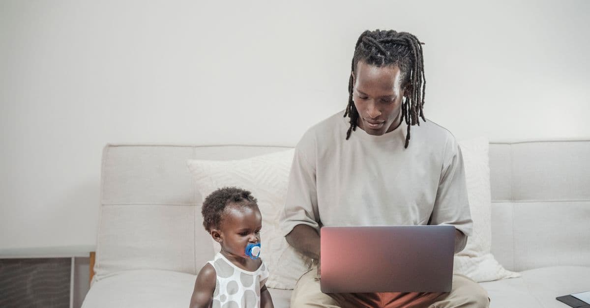 Vater arbeitet in Teilzeit im Homeoffice und betreut nebenbei sein Baby