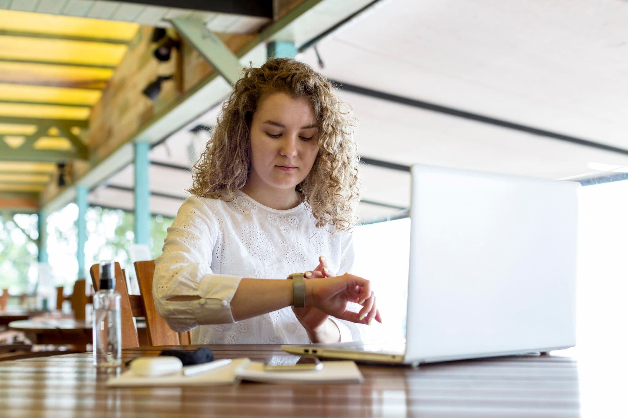 Werkstudentin arbeitet in einem Café und achtet auf die Uhrzeit wegen der 20-Stunden-Regel